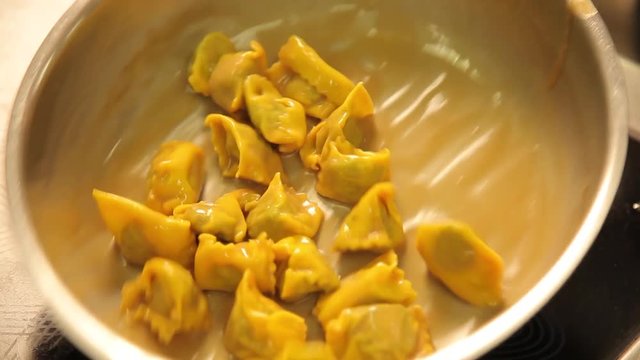 chef coooking ravioli agnolotti with sauce