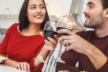 Young couple having romantic evening at home in the kitchen cheers close-up