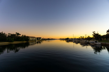 Obraz premium USA, Florida, Sunset behind water of large river with boats and houses