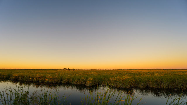 USA, Florida, Glowing orange sky over everglades nature landscape after sunset