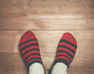 Foots with winter stockings on a wood background.