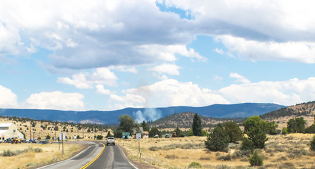 Fire in the distance in Northern California - Driving on 2-lane road near Susansville with mountains and smoke in the distance - selective focus