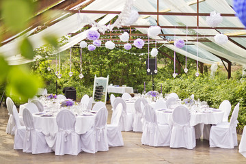 Outdoor wedding in Scandinavian style in old abandoned greenhouse. White tablecloth, white chairs,...