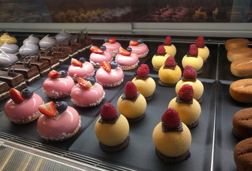 Cakes in confectionery. Display of pastries topped 