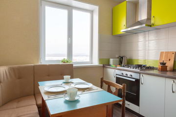 design of green white kitchen. soft corner with a table