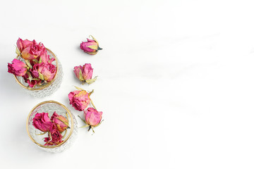 composition of pink roses and glass vases on a marble table. holiday concept, flat lay, top view
