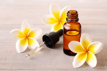 Plumeria Essential Oil Perfume and yellow plumeria flowers on the wooden table