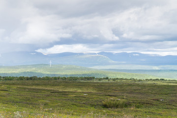 Fototapeta na wymiar Steppe, hills and clouds in soft shades, Sweden