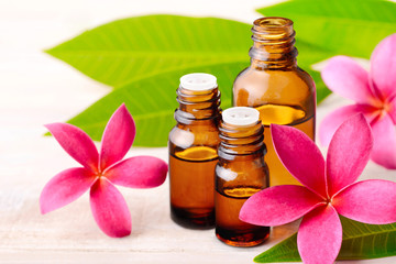 Plumeria Fragrance Oil Perfume and red plumeria flowers on the wooden table