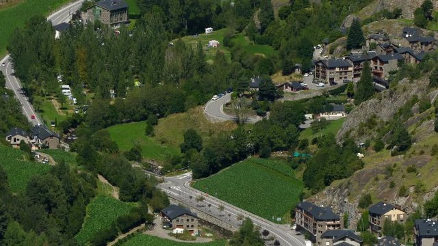 Andorra from above. Smooth camera movement: Tilt down.Panoramic aerial view of the  valley bottom of "Ordino" with green meadows, small villages and main road , a summer day. 