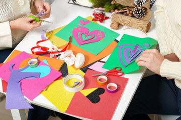 young couple making decorations from paper for Valentine day, top view - romantic and love concept