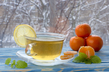 a cup of tea and sweets, on a blue wooden background