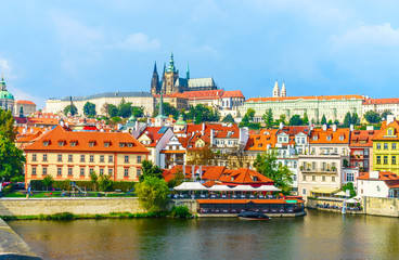 Fototapeta premium Prague Castle. The Charles Bridge. Medieval fortress. The Vltava River. Red tiled roofs. View from Charles Bridge