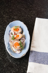 Rolled herring in vinegar, served with onions and lemon. Russian Appetizer.