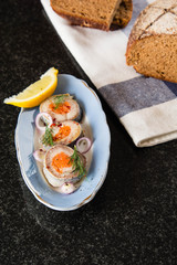 Rolled herring in vinegar, served with onions and lemon. Russian Appetizer.