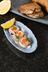 Rolled herring in vinegar, served with onions and lemon. Russian Appetizer.