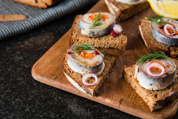Rolled herring in vinegar, served with onions and lemon. Russian Appetizer.