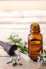 fresh rosemary flowers and essential oils on the table