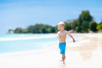 Child on tropical beach. Sea vacation with kids.