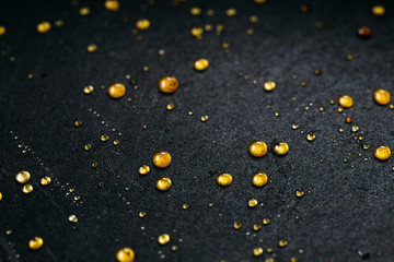 Abstract black background with golden glitter dots. Caramel on frying pan