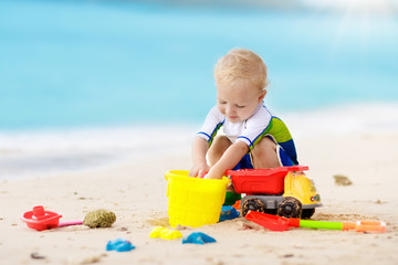 Kids play on tropical beach. Sand and water toy.