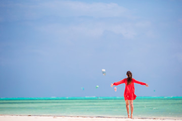 Fototapeta na wymiar Young beautiful woman on tropical seashore. Back view of young girl in beautiful dress background the sea