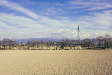 Brown field on a sunny day with a wind mill