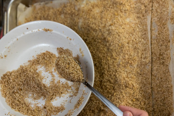 Sprinkling grated walnut over pie crusts