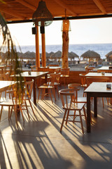 The restaurant on the beach in the shade of the low sun at sunset