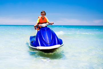 Obraz premium Teenager on jet ski. Teen age boy water skiing.