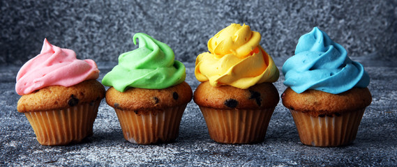 Tasty cupcakes on grey background. Birthday cupcake in rainbow colors