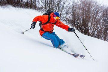 Fototapeta na wymiar Powder day in Carpathian mountains. A skier is riding down the hill.