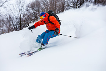 Powder day in Carpathian mountains. A skier is riding down the hill.