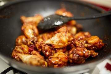 Chicken wings caramelizing in the pan