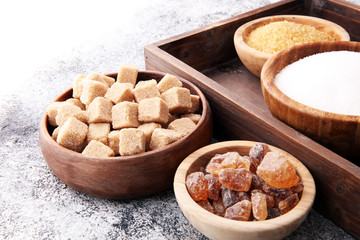 Various types of sugar, brown sugar and white on grey table