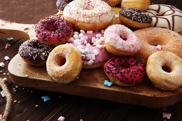 assorted donuts with chocolate frosted, pink glazed and sprinkles donuts.