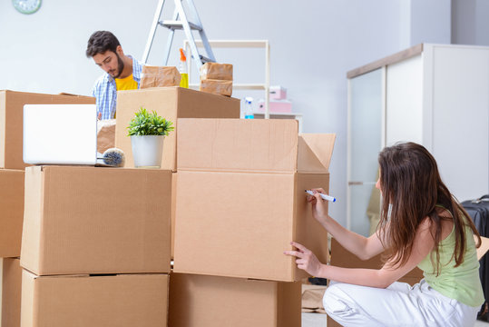 Young family unpacking at new house with boxes