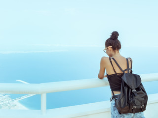Fototapeta premium Beautiful young tourist girl with backpack near sea