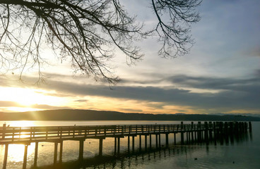 Fototapeta na wymiar Sonnenaufgang hinter dem Bootssteg am Starnberger See