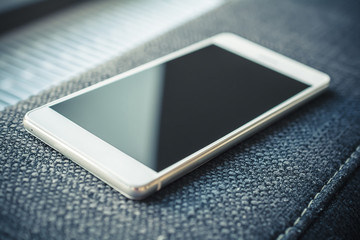 Smartphone With Reflection Lying On The Armrest Of A Couch