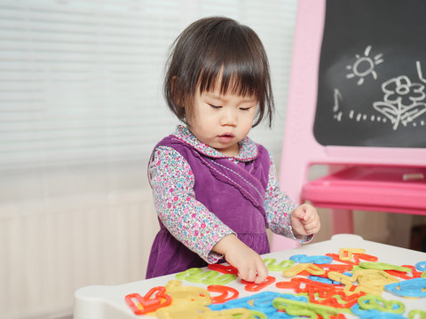 baby girl playing geometry blocks at home