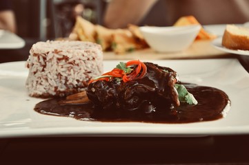 meat grilled with fresh vegetable salad and brown rice on a white plate. a top view of a horizontal, food decoration concept