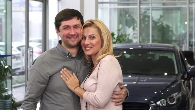 Excited mature couple embracing high fiving laughing joyfully after purchasing a new automobile at the dealership driving travelling family love maturity future travel ownership