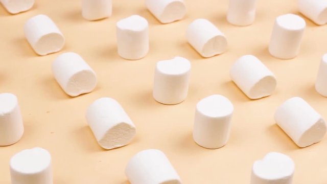 Sweet marshmallows on pastel yellow background.