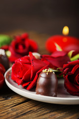 Red candles and roses on the wooden table