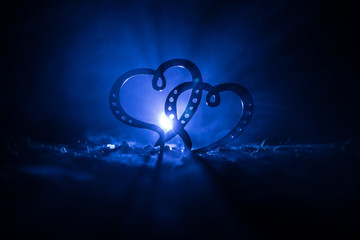 Valentine greeting concept.Two hearts on dark toned foggy background. Transparent hearts.