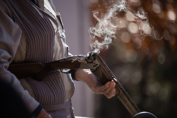 Man holding a smoking gun in the Fall
