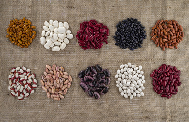 Different varieties of beans on the background of sacking.