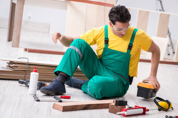 Contractor working on laminate wooden floor 