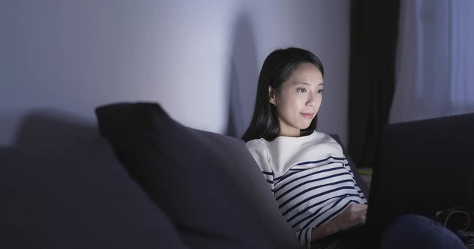 Woman working on notebook computer at night
